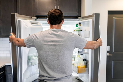 A man looking in a refrigerator.