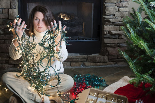 Homeowner holding a tangle of holiday lights.